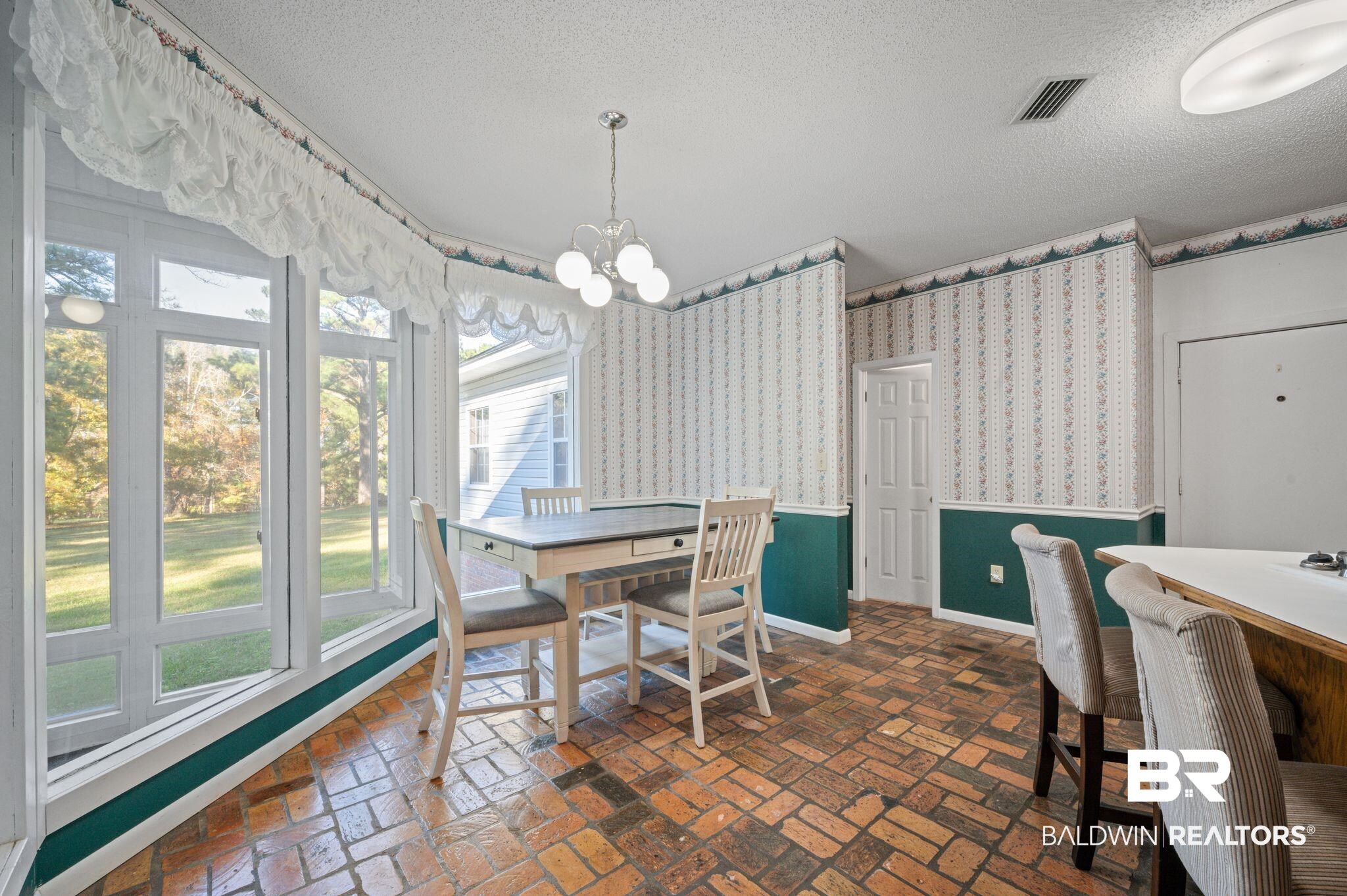 15801 Maytower Road Bay Minette, AL 36507 - Photo 16 of 43 Dining space featuring a textured ceiling and a notable chandelier