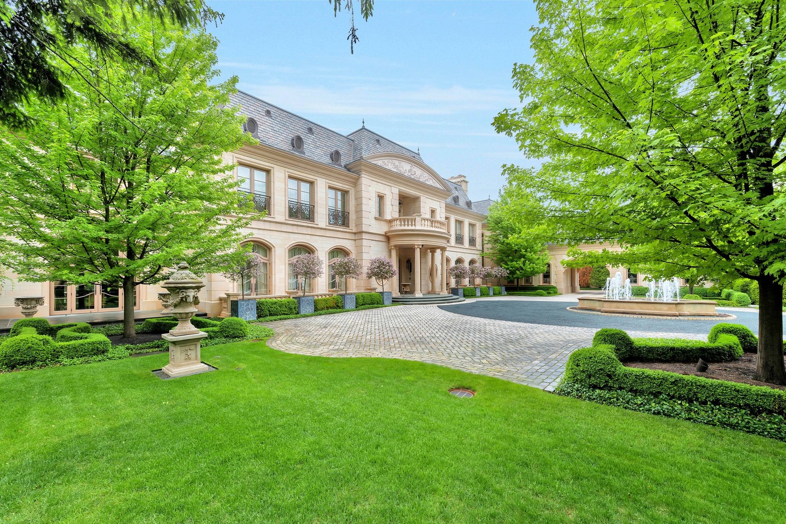 a front view of a house with garden and trees