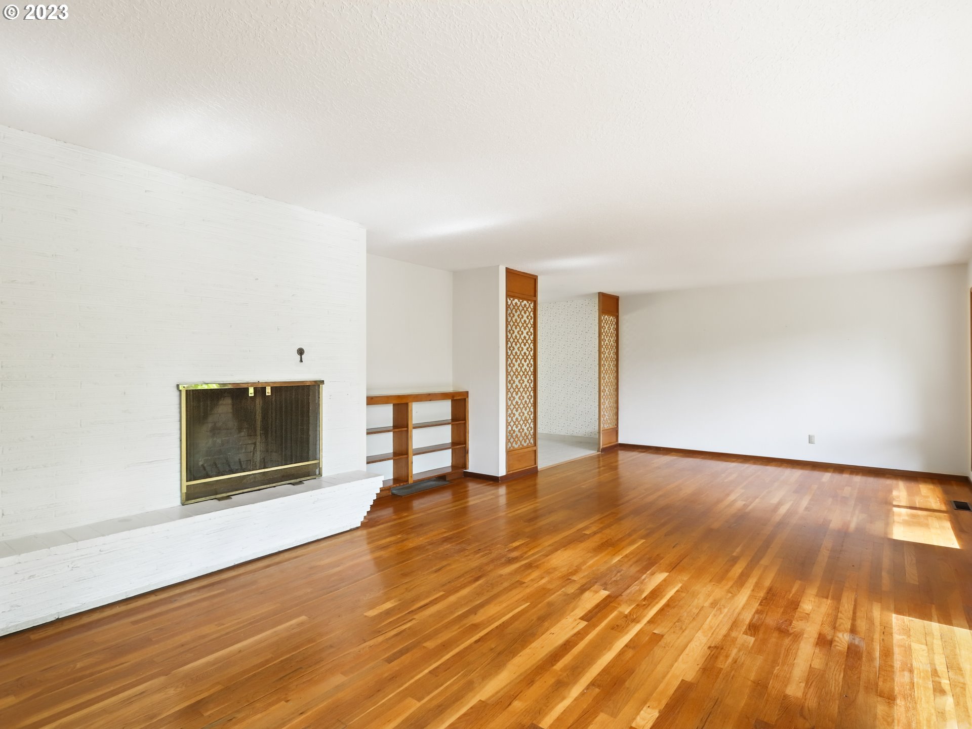 1975 Mapleleaf Road Lake Oswego, OR 97034 - Photo 9 of 37 a view of an empty room with wooden floor and a fireplace