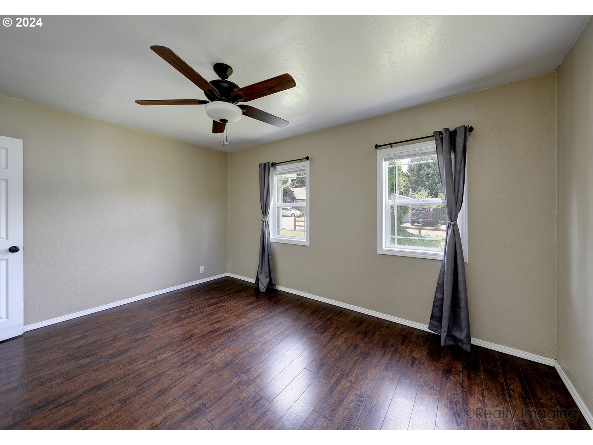 4424 Northeast 115th Avenue Portland, OR 97220 - Photo 13 of 24 an empty room with wooden floor ceiling fan and windows