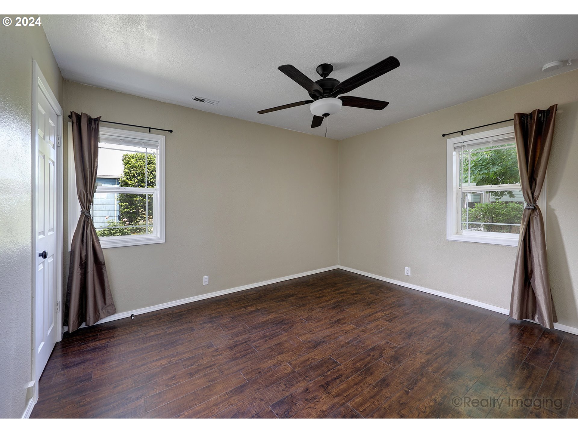 4424 Northeast 115th Avenue Portland, OR 97220 - Photo 15 of 24 an empty room with wooden floor a ceiling fan and windows