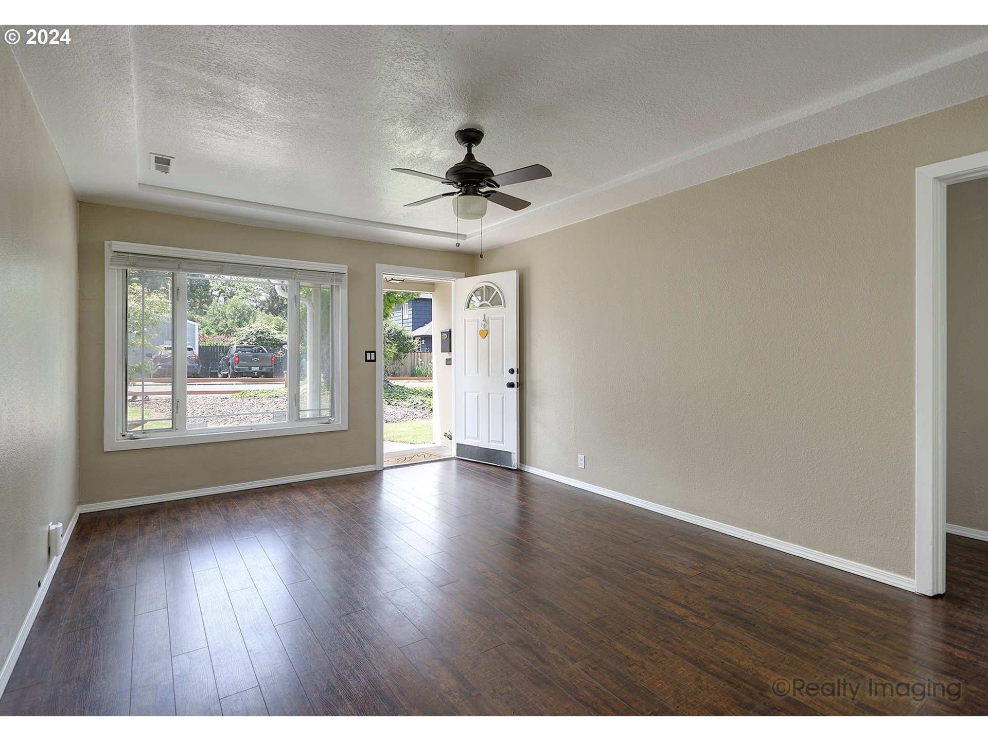 4424 Northeast 115th Avenue Portland, OR 97220 - Photo 6 of 24 an empty room with wooden floor chandelier fan and windows