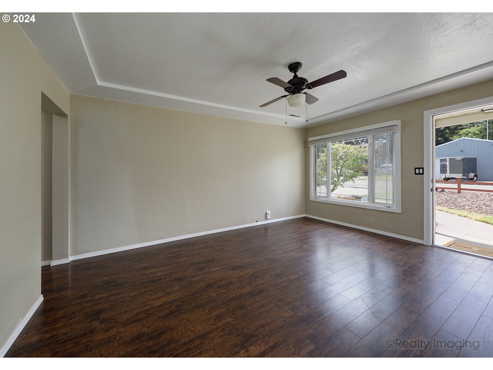 4424 Northeast 115th Avenue Portland, OR 97220 - Photo 7 of 24 an empty room with wooden floor ceiling fan and windows