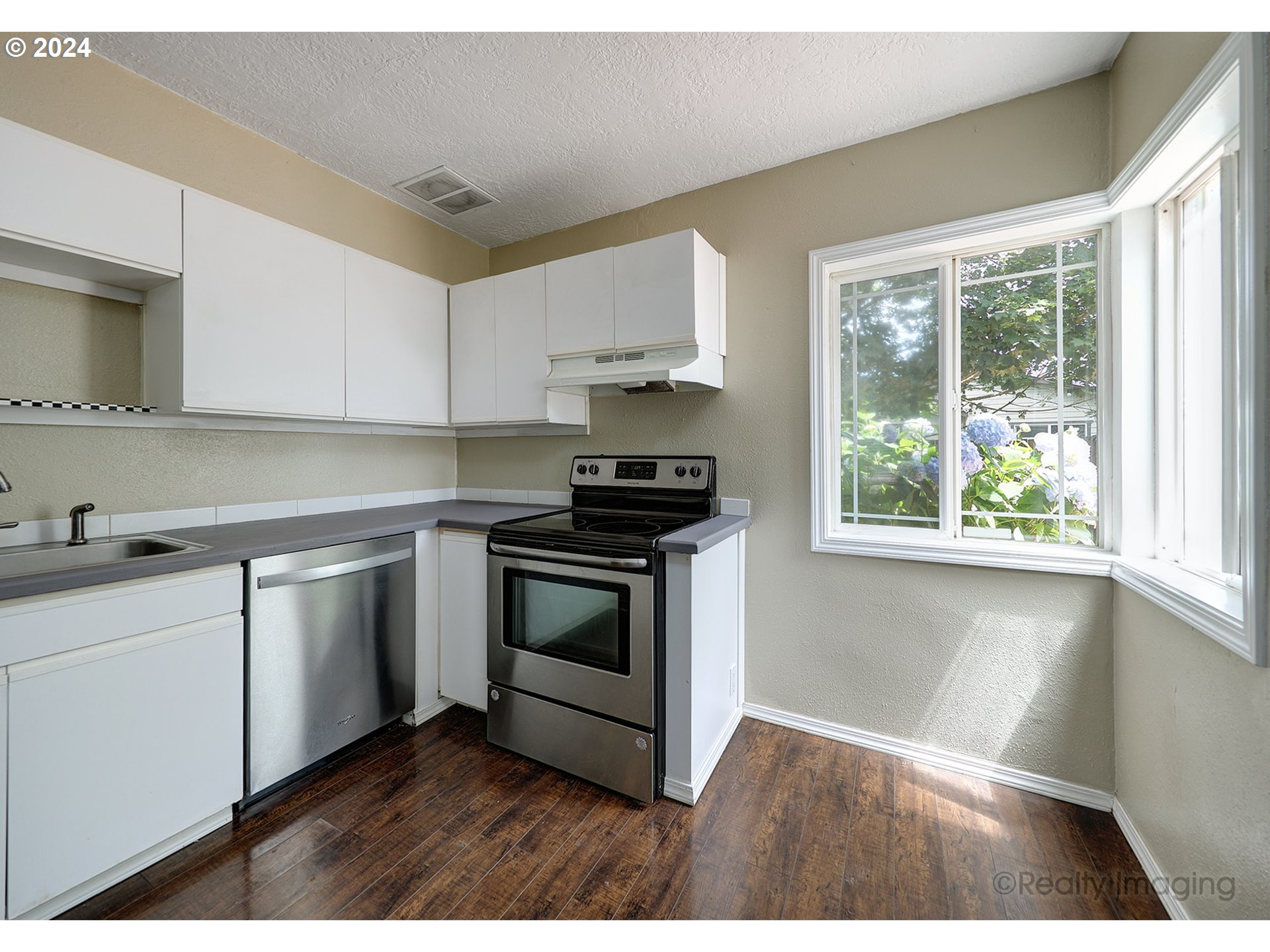 4424 Northeast 115th Avenue Portland, OR 97220 - Photo 9 of 24 a kitchen with a sink stove top oven and cabinets