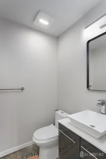 a bathroom with a sink a toilet and mirror