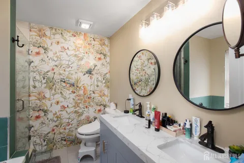 a bathroom with a sink a toilet and a mirror