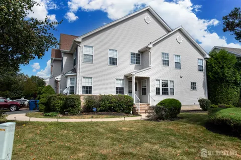a view of a white house with a yard and plants