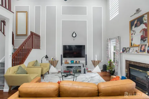 a living room with furniture a flat screen tv and a fireplace