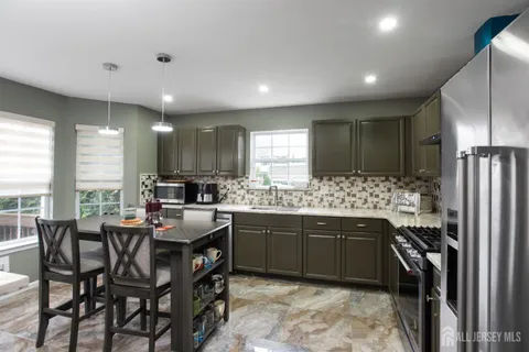 a kitchen with refrigerator and chairs