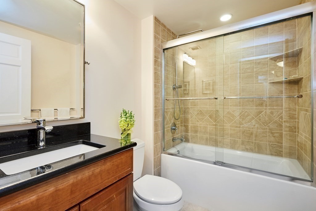 197 8th Street, Unit PH230 Boston, MA 02129 - Photo 15 of 29 a bathroom with a bathtub shower sink vanity and toilet