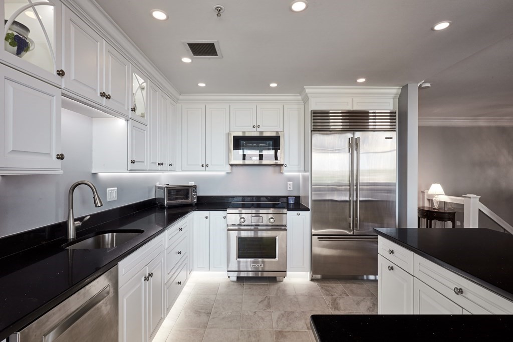 197 8th Street, Unit PH230 Boston, MA 02129 - Photo 5 of 29 a kitchen with a sink stainless steel appliances and cabinets