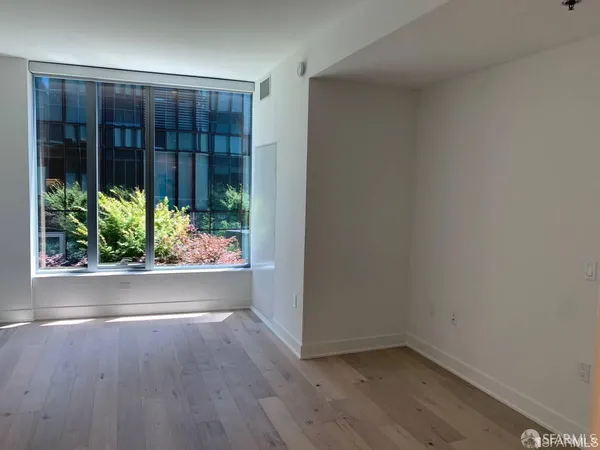 an empty room with wooden floor and a window