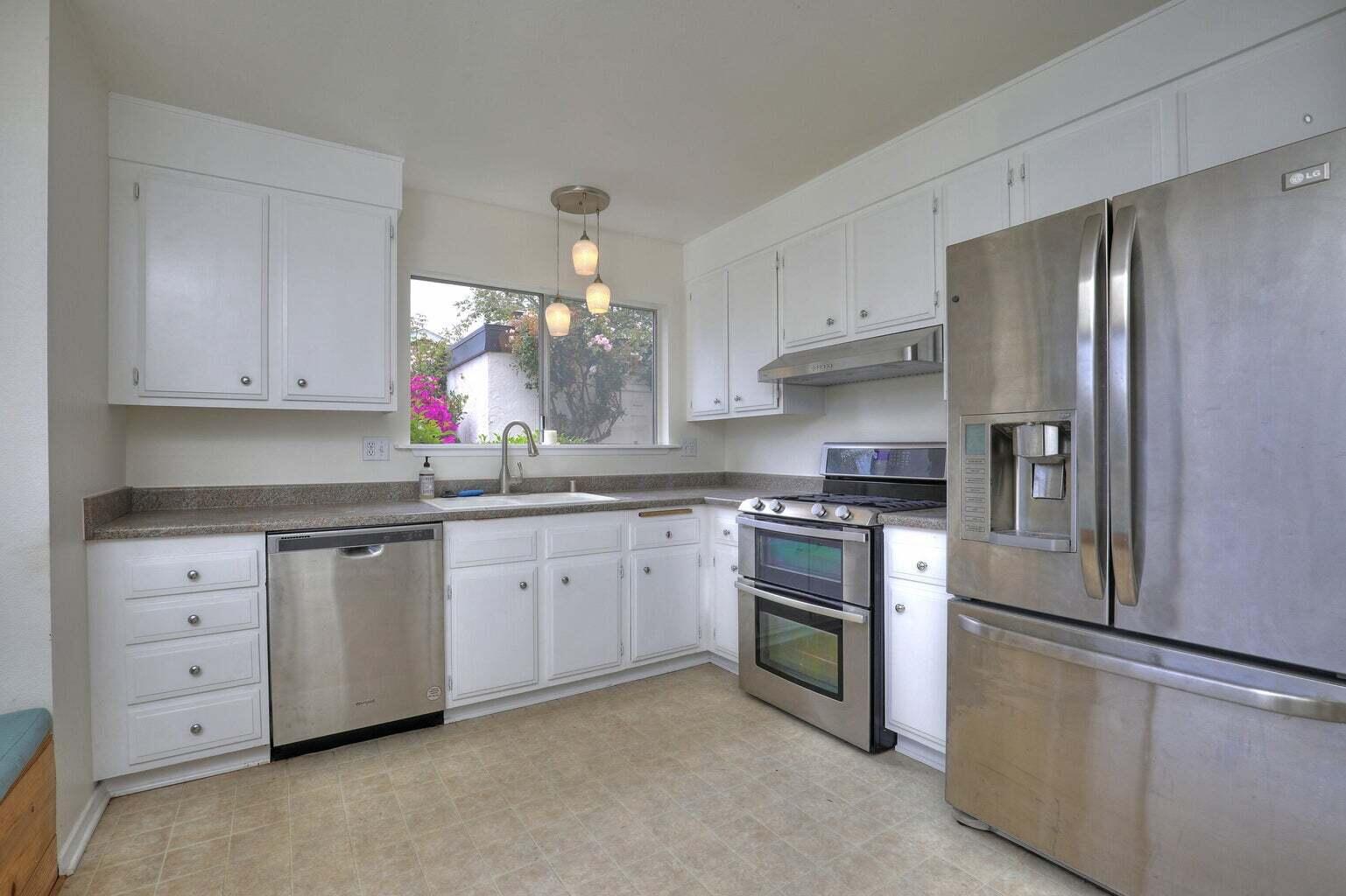 4715 Aragon Drive Carpinteria, CA 93013 - Photo 6 of 29 a kitchen with granite countertop white cabinets white stainless steel appliances and a sink