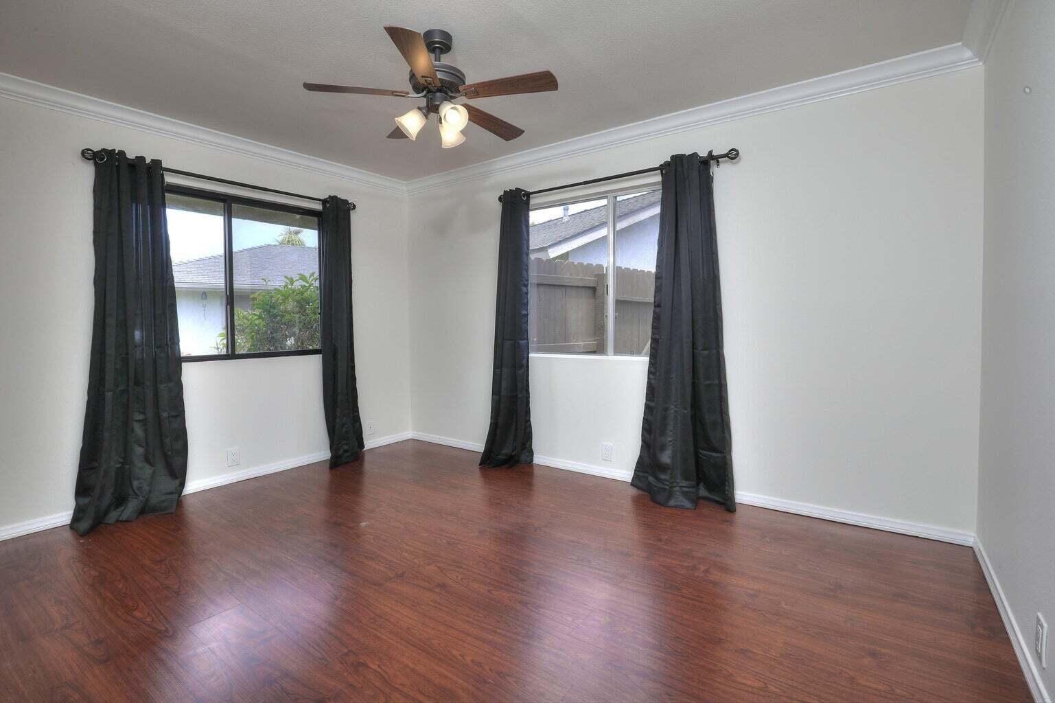 4715 Aragon Drive Carpinteria, CA 93013 - Photo 8 of 29 an empty room with wooden floor and windows