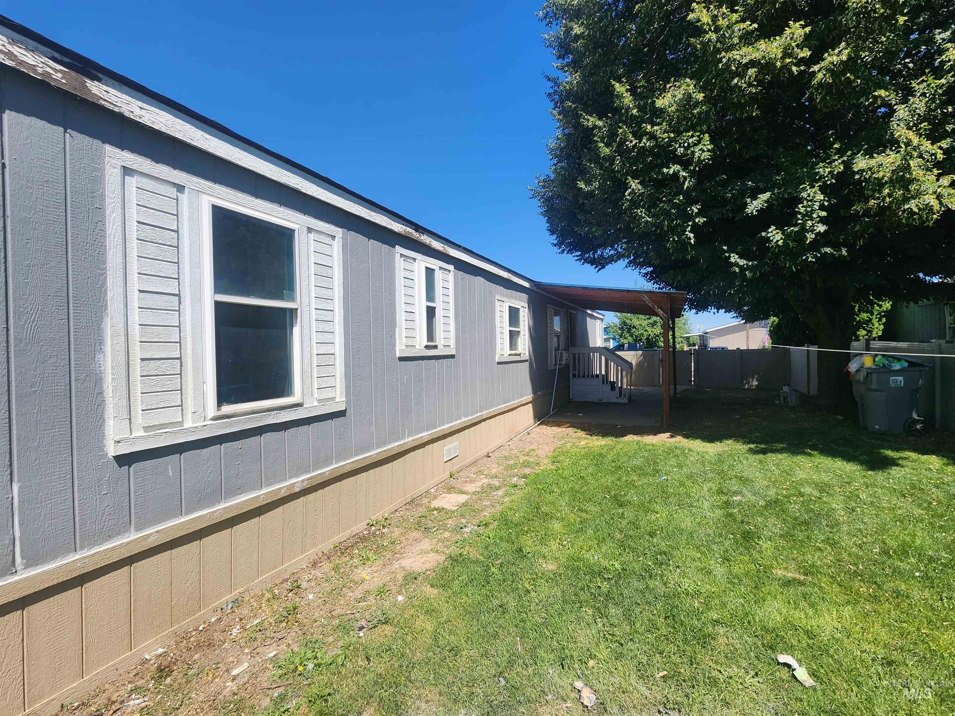 616 North Kings Road Nampa, ID 83687 - Photo 12 of 12 Side exterior of the property featuring gray vertical siding and a tan foundation
