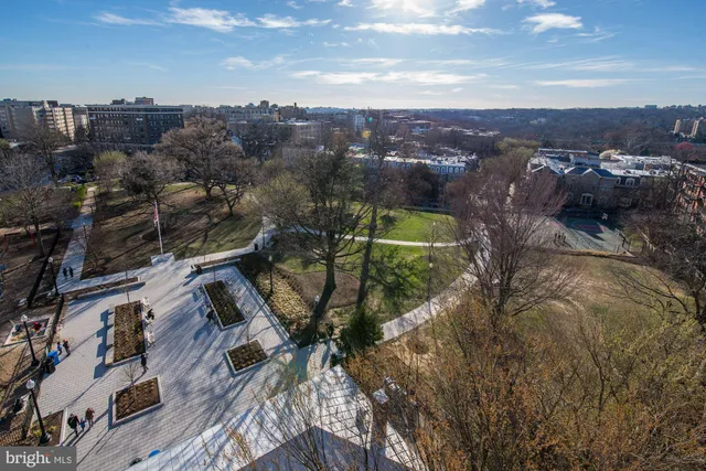 a street view with tall buildings and cars parked on road