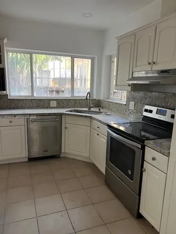 a kitchen with a stove sink and cabinets