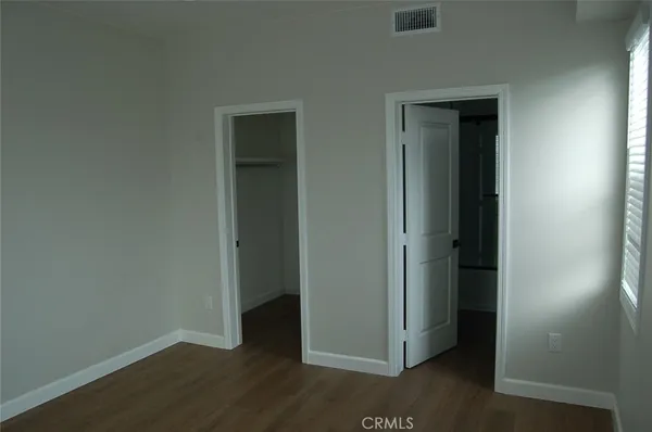 an empty room with wooden floor and closet