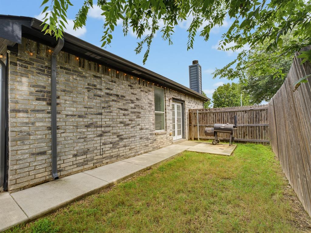 600 Stirling Road Rhome, TX 76078 - Photo 34 of 38 Private fenced backyard featuring a brick exterior and a concrete patio