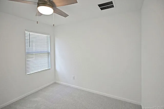 an empty room with a mirror and a fan