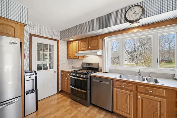 a kitchen with stainless steel appliances granite countertop a sink a stove and a refrigerator