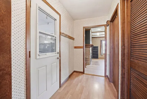 a view of a hallway with wooden floor and stairs