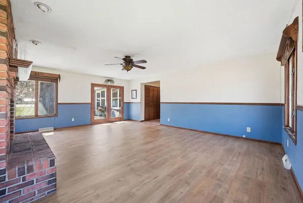 a view of an empty room with a window and wooden floor