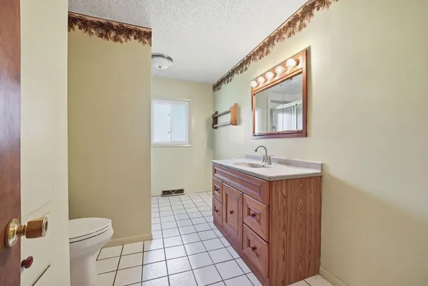 a bathroom with a granite countertop sink a mirror and a toilet
