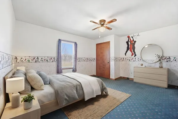 a spacious bedroom with a bed and ceiling fan