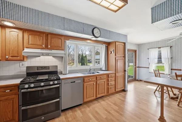 a kitchen with stainless steel appliances a stove a sink and cabinets