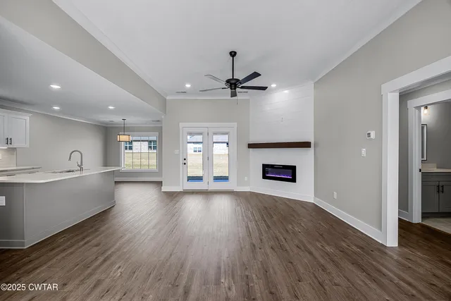 a view of an empty room with a fireplace and a window