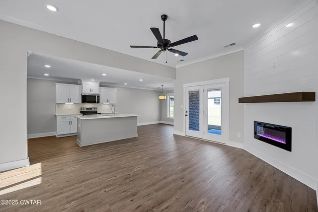 a view of kitchen with stainless steel appliances kitchen island wooden floors and view living room