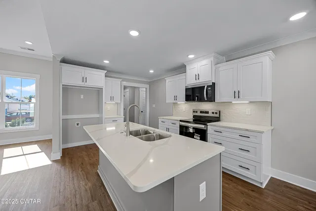 a kitchen with white cabinets appliances and sink