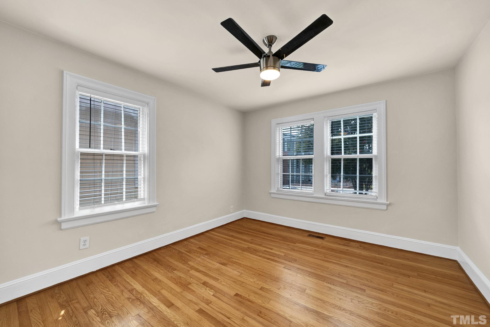 10 Dixie Trail Raleigh, NC 27607 - Photo 13 of 27 an empty room with wooden floor and windows
