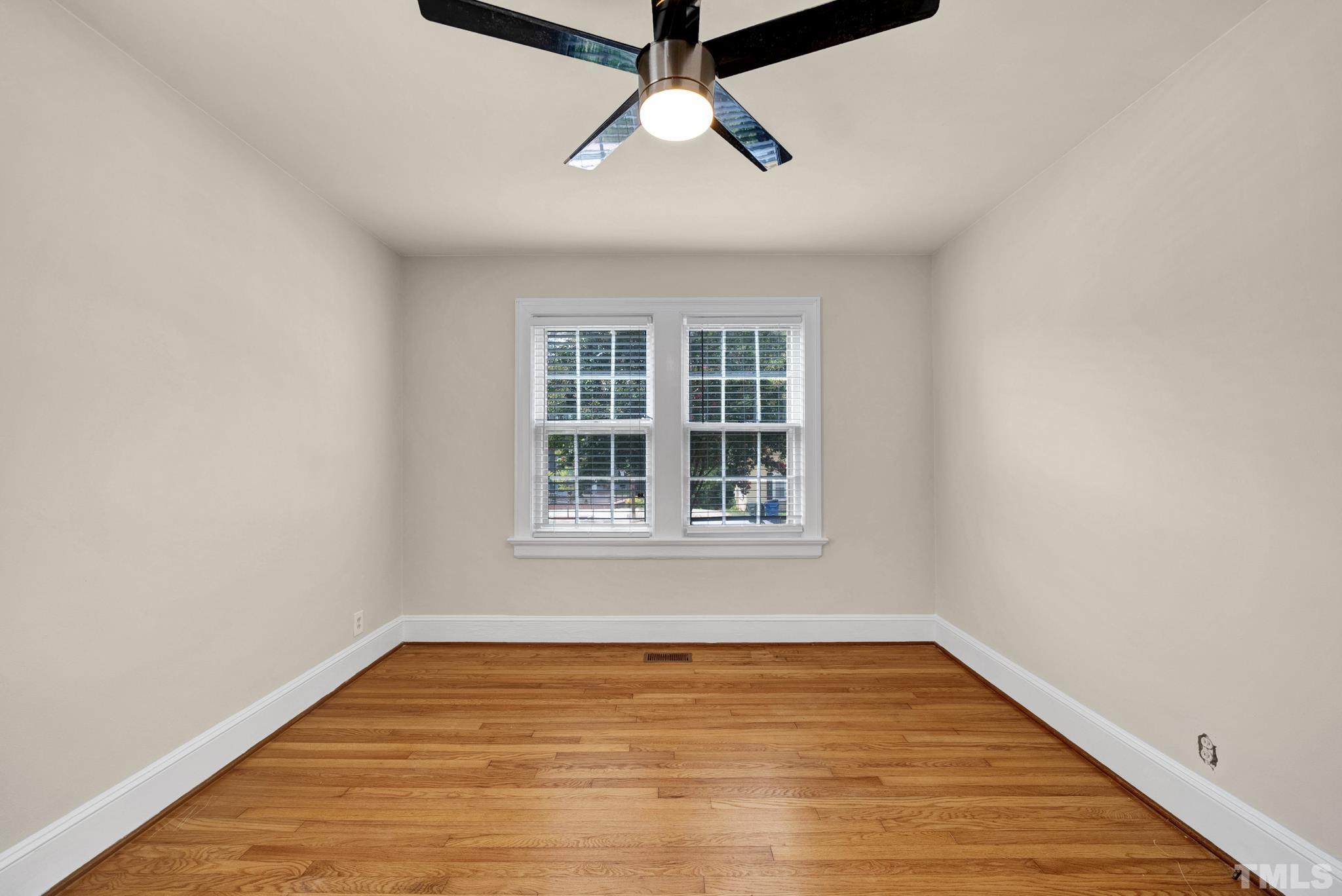 10 Dixie Trail Raleigh, NC 27607 - Photo 14 of 27 a view of an empty room with wooden floor and a window