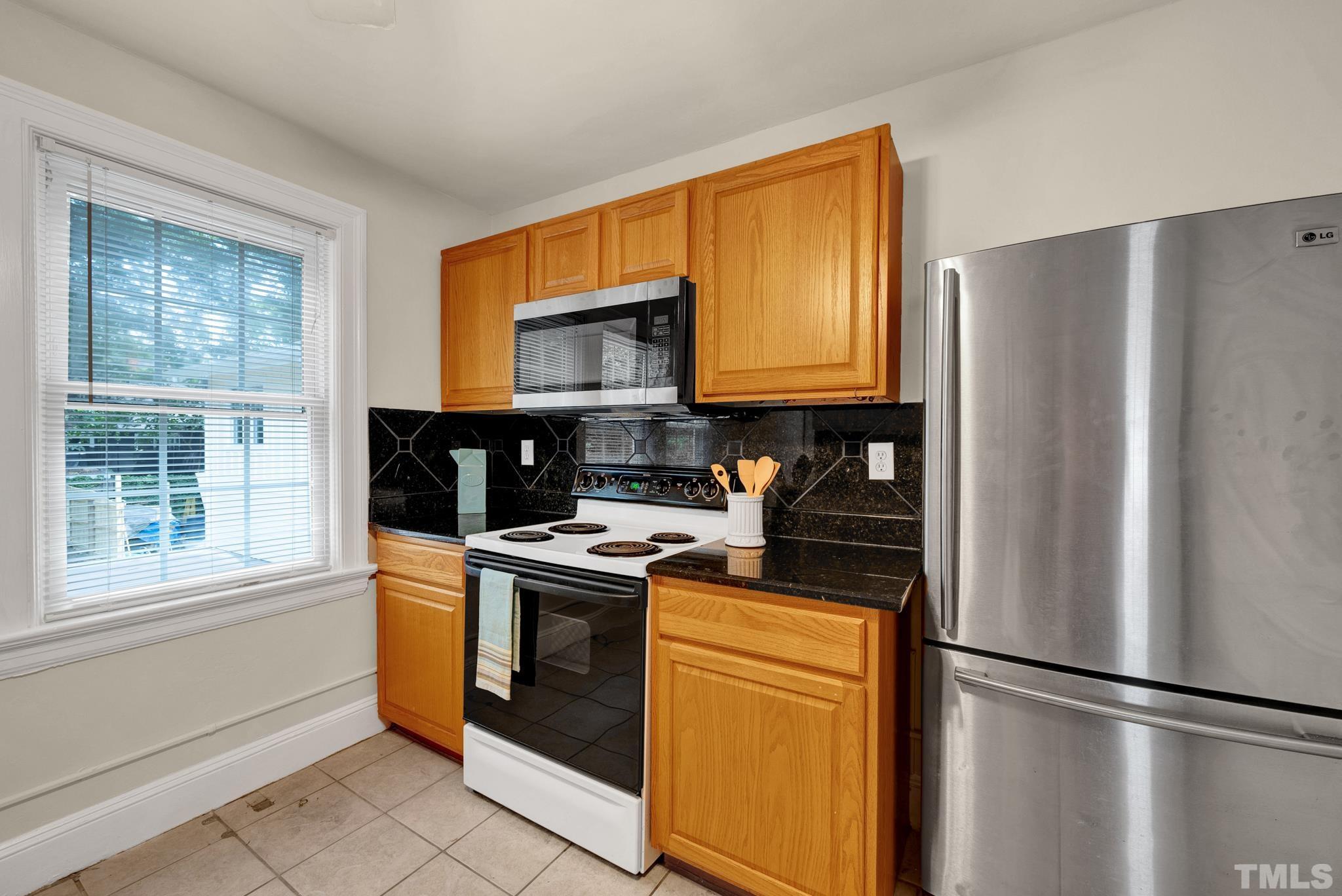 10 Dixie Trail Raleigh, NC 27607 - Photo 22 of 27 a kitchen with stainless steel appliances granite countertop a refrigerator stove top oven and sink