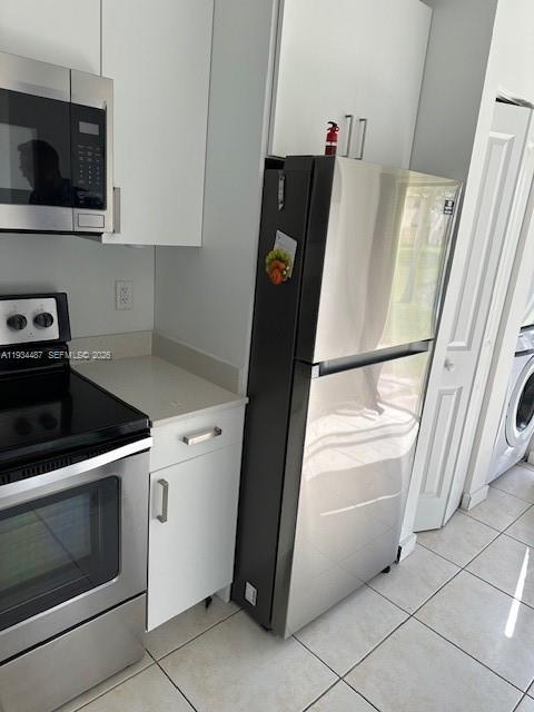 1250 Southeast 26th Street, Unit 102 Homestead, FL 33035 - Photo 4 of 16 a kitchen with a stove and a microwave