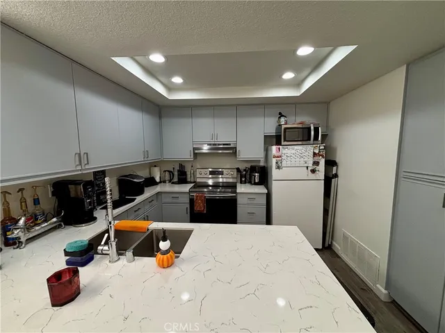 a kitchen with sink refrigerator and stove