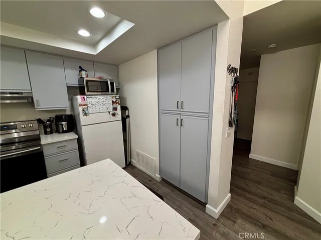 a kitchen with stainless steel appliances a refrigerator and wooden floor