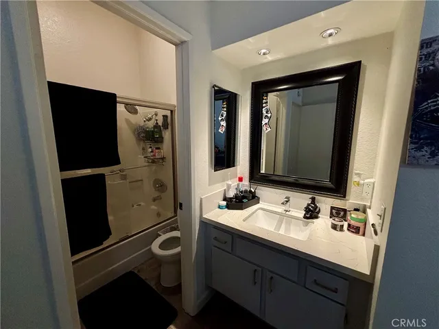a bathroom with a sink a toilet and a mirror