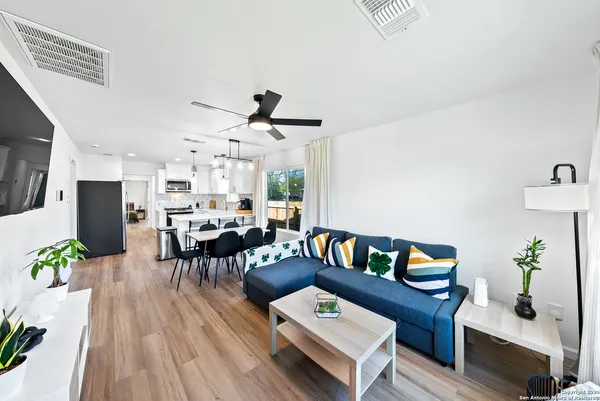 a living room with furniture and a wooden floor