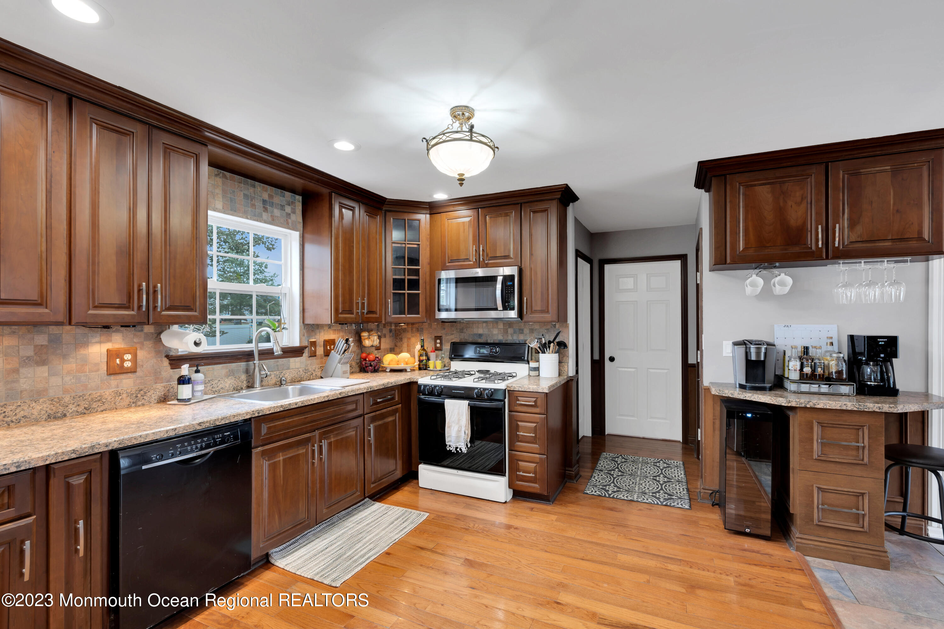 5 Autumn Drive Howell, NJ 07731 - Photo 21 of 50 a kitchen with stainless steel appliances granite countertop wooden cabinets a sink dishwasher a stove and a refrigerator with wooden floor