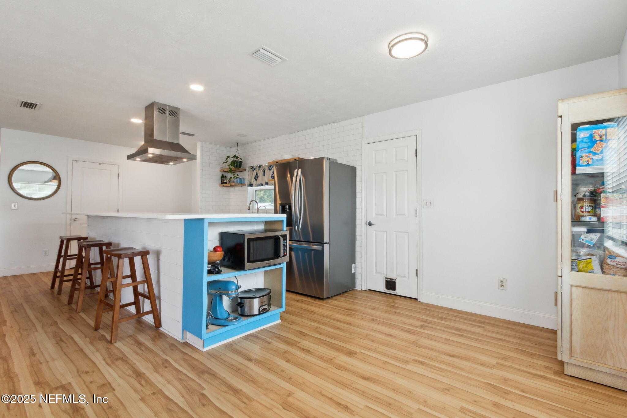 234 Hawthorne Road St. Augustine, FL 32086 - Photo 16 of 29 a hallway with a stove and a refrigerator with wooden floor
