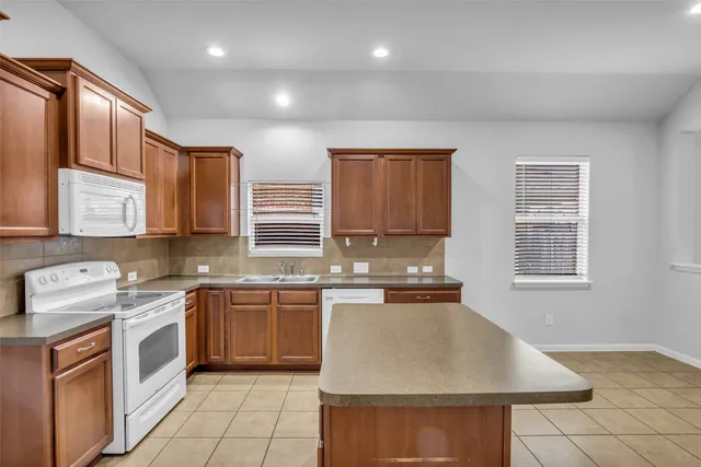 a kitchen with stainless steel appliances granite countertop a sink stove and cabinets