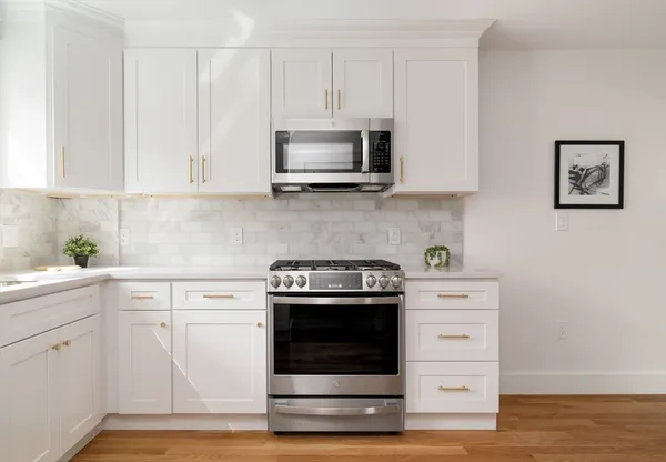 a kitchen with white cabinets and stainless steel appliances