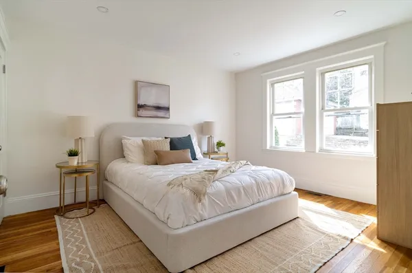 a bedroom with a bed and wooden floor