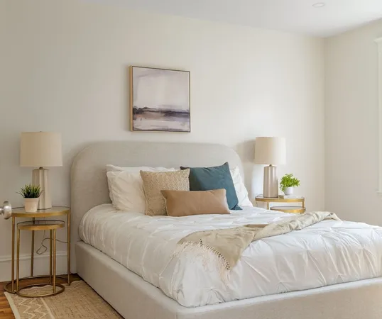 a bedroom with a bed and a lamp on the dresser