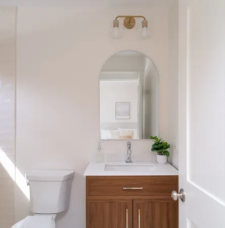 a bathroom with a sink a toilet and a mirror