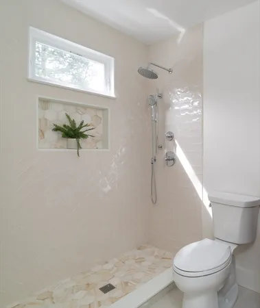 a white toilet sitting next to a bathroom sink