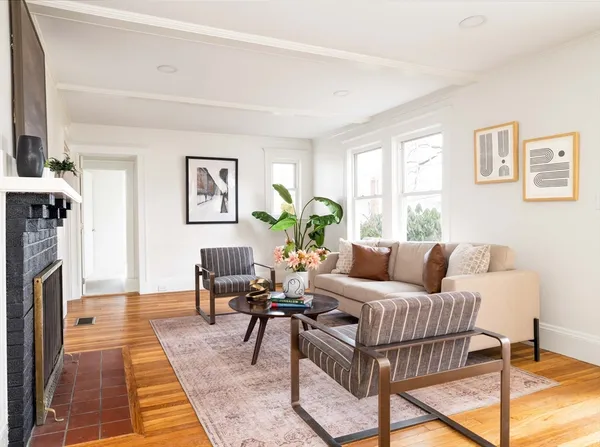 a living room with furniture fireplace and a window